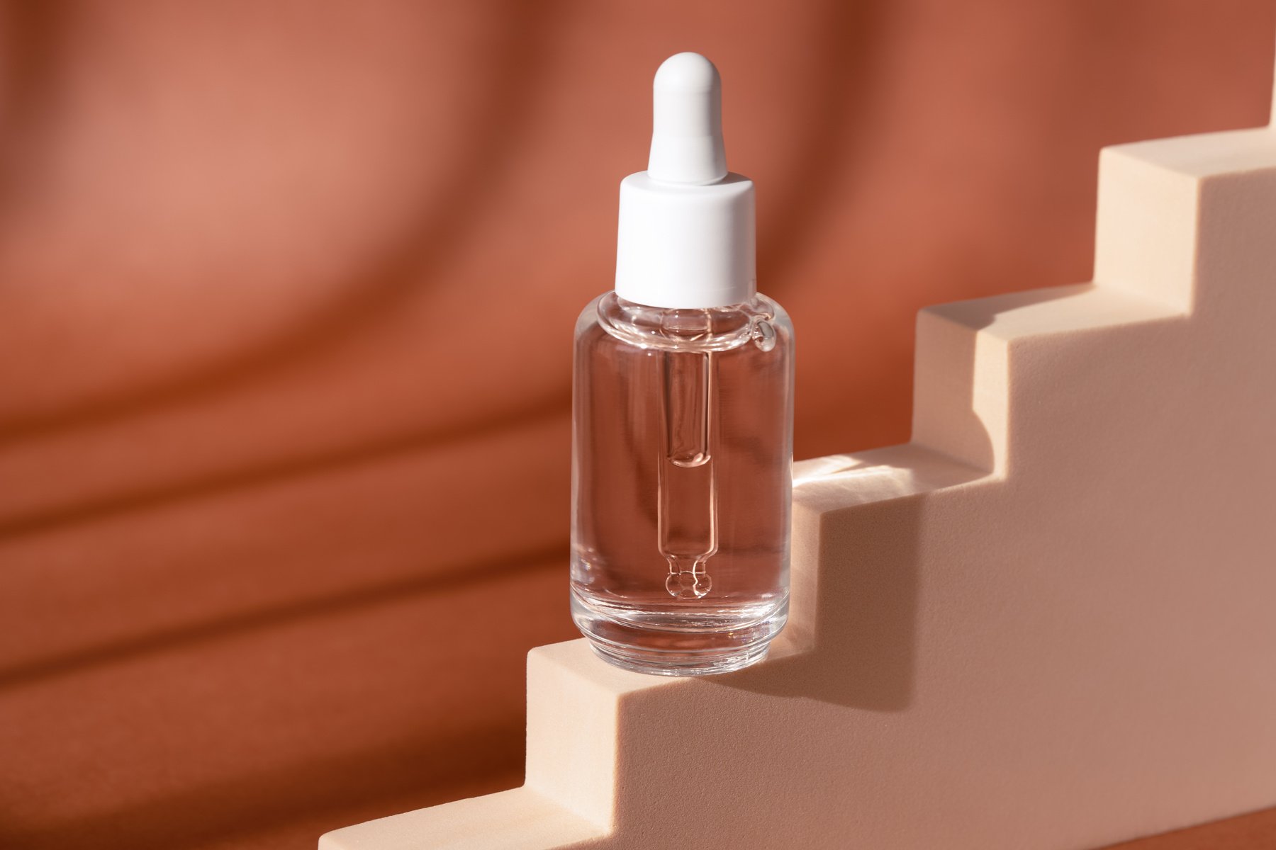 Glass Cosmetic Bottle Mock up on Staircase Podium. Hyaluronic Acid, Serum Skincare Product on Beige Pedestal.